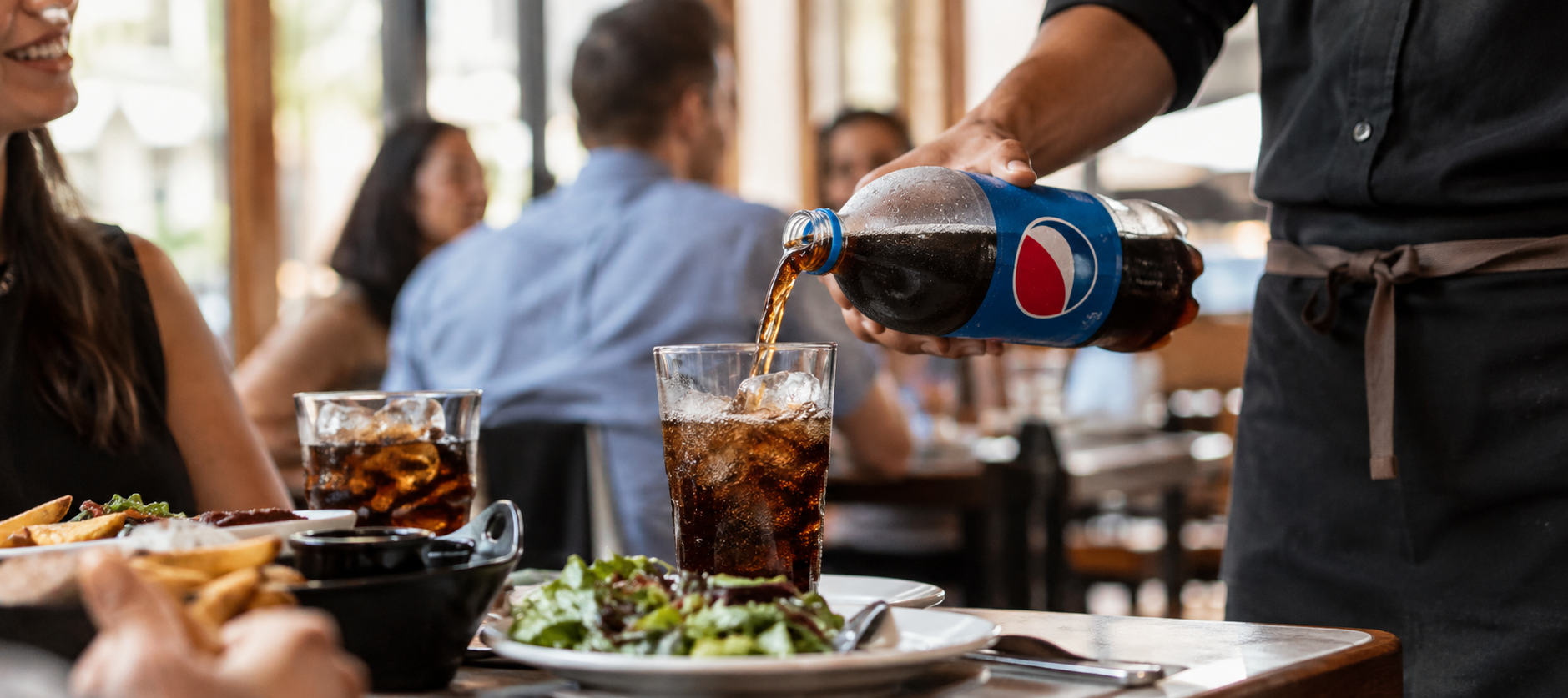 Pepsi, die in Gläser gegossen wird